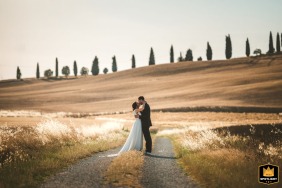 Set against the rolling hills of Crete Senesi, Tuscany, a couple embraces, the breathtaking Italian landscape providing a romantic backdrop for their kissing portrait.